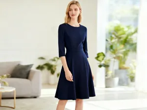 Elegancki mężczyzna w granatowej marynarce i czarnych spodniach w nowoczesnym, minimalistycznym wnętrzu.