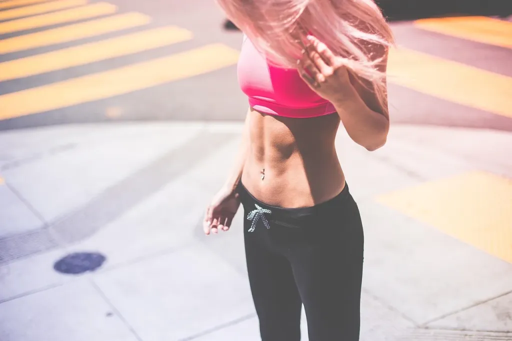 Zestaw wysokiej jakości akcesoriów sportowych, takich jak buty do biegania, bidon i opaska fitness na neutralnym tle.